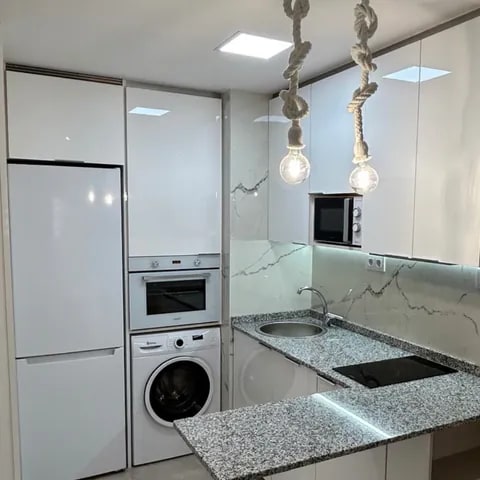 Carpintería a medida en cocina compacta con integración de electrodomésticos - David Carpintería Cocina compacta con mobiliario de carpintería blanco y electrodomésticos integrados