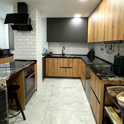 Carpintería a medida para cocina en madera y negro - David Carpintería Cocina en U con mobiliario de carpintería en madera y encimera negra